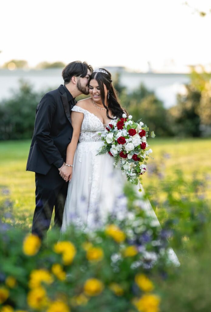 bride & groom in flower garden on lush greenscape