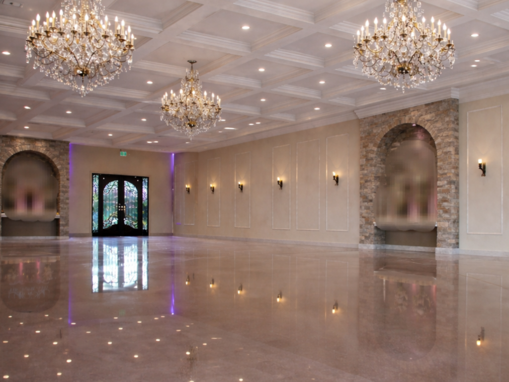 large ballroom, multiple crystal chandeliers, stone archways, iron doors, indoor reception