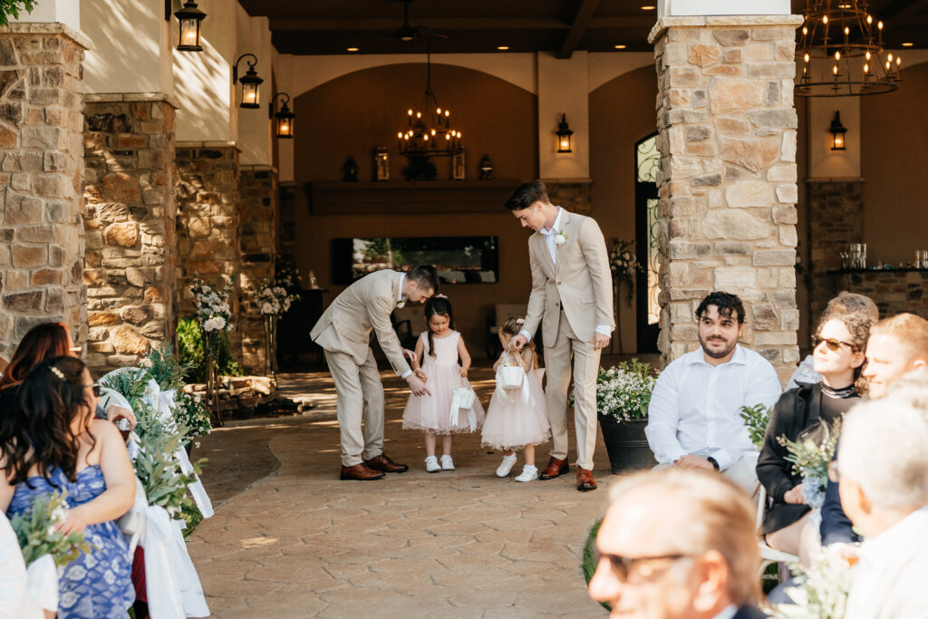 garden wedding with flower girls and ring bearers, walking down wedding aisle, romantic lighting, chandeliers, stone work, bricks, bridgerton vibe