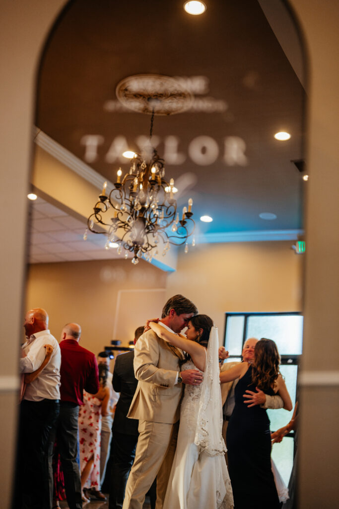 wedding reception dance with bride and groom, chandelier, dance floor, event space, dimmable lighting